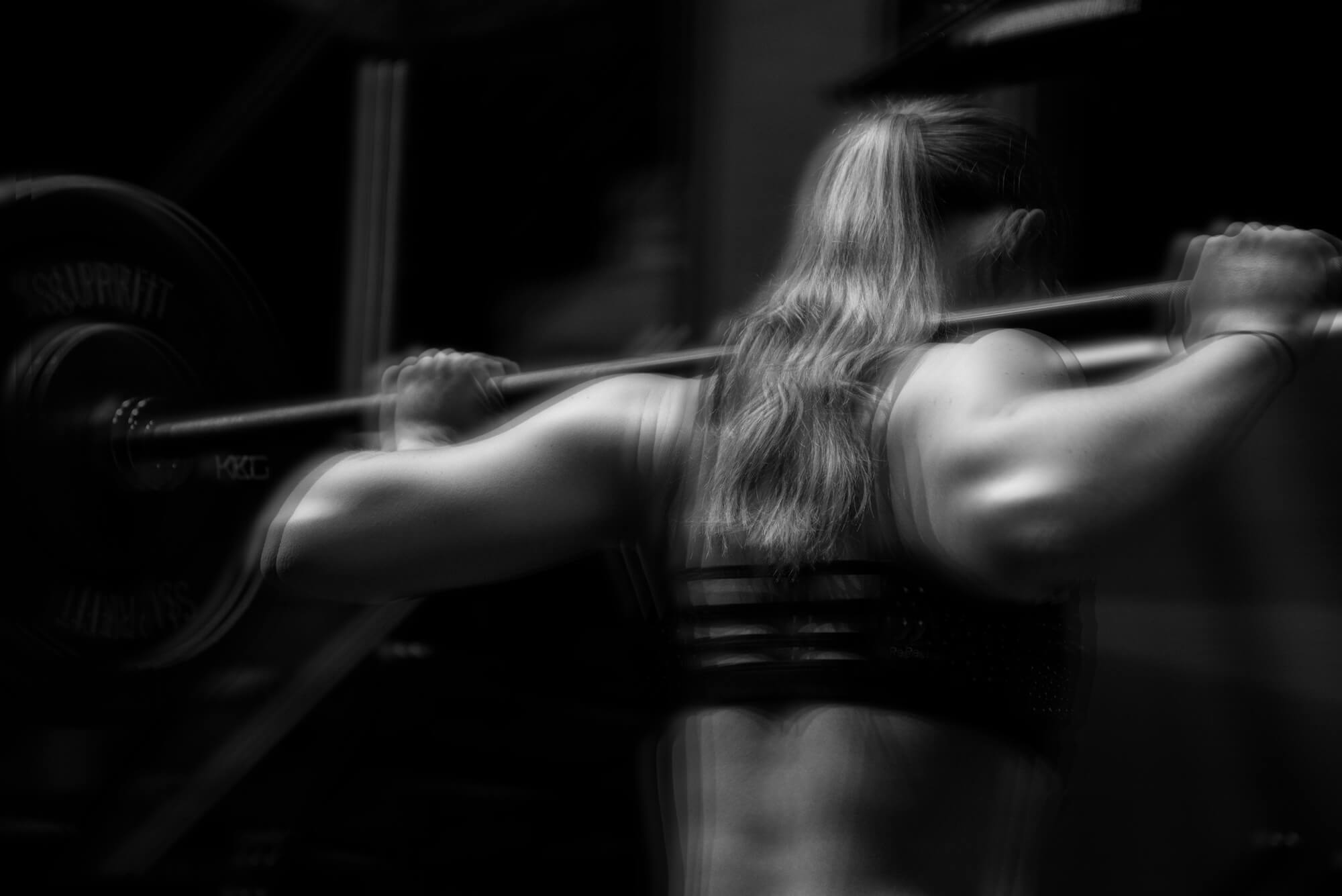 An athlete lifting a barbell, captured with motion blur